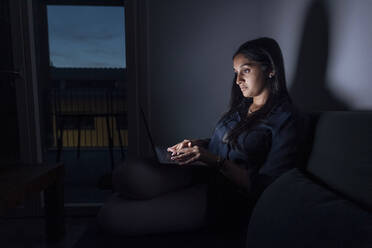 Frau benutzt Laptop in einem Zimmer zu Hause - MEUF08701