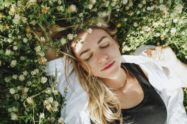 Woman relaxing on meadow of clover flowers - MDOF00298