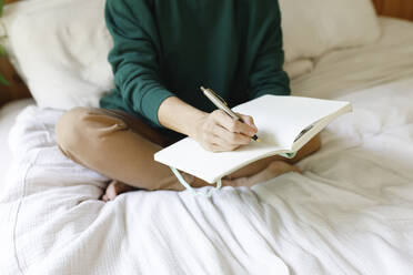 Woman writing notes in diary - TYF00453