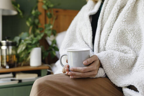 Woman sitting with cup of tea at home - TYF00462