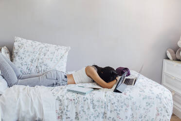 Mädchen macht ein Nickerchen mit drahtlosen Technologien auf dem Bett zu Hause - EGHF00666