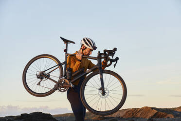 Radfahrer mit Fahrrad vor dem Himmel - JPTF01107