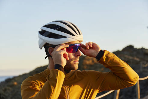 Radfahrer mit Helm und Schutzbrille an einem sonnigen Tag - JPTF01109