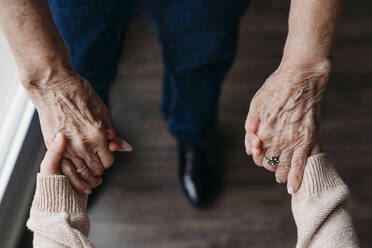 Senior woman holding granddaughter's hands at home - EBBF07266