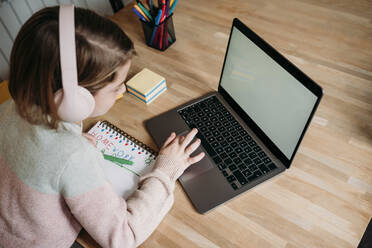 Girl studying through laptop on table - EBBF07316