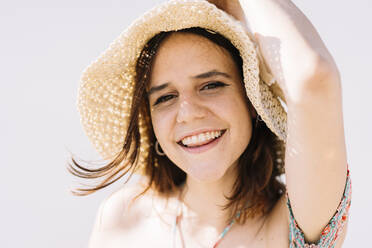 Happy woman wearing hat on sunny day - DAMF01150