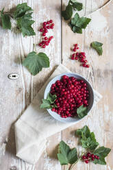 Schale mit frischen roten Johannisbeeren auf Holztisch - EVGF04165