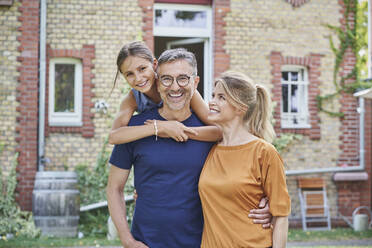 Happy family enjoying in front of house - RORF03181