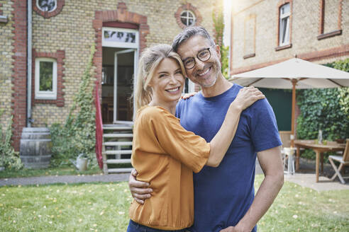 Happy woman embracing man in back yard - RORF03184