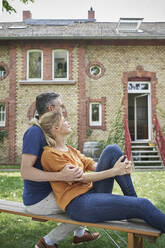 Couple sitting on bench in garden - RORF03198