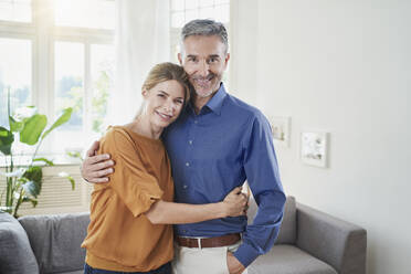 Smiling woman embracing man at home - RORF03219