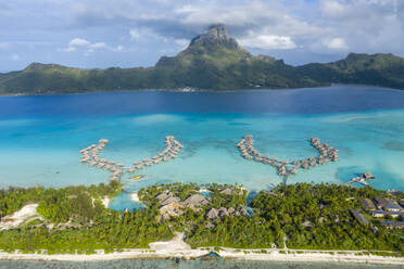 Aerial view of wooden huts from a luxury hotel along the reef in Tahiti, French Polynesia. - AAEF16970