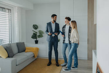A happy young couple buying their new home and meeting real estate agent in apartment. - HPIF00945