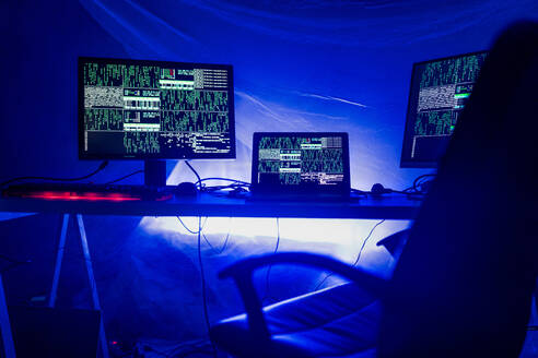 Ein Internet-Hacker-Arbeitsplatz im dunklen Büro, Cyberwar-Konzept. - HPIF00976