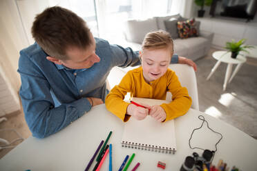 A father with his little daughter with Down syndrome learning at home. - HPIF01048