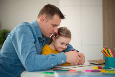 A father with his little daughter with Down syndrome learning at home. - HPIF01059