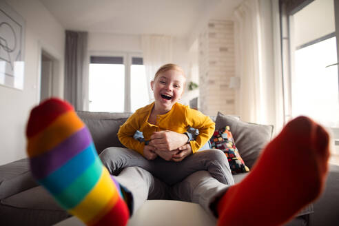 Ein fröhliches kleines Mädchen mit Down-Syndrom, das mit seinem Vater zu Hause Spaß hat. - HPIF01066