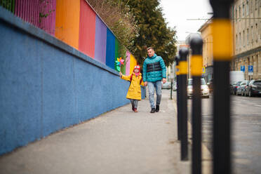 Ein Vater bringt seine kleine Tochter mit Down-Syndrom zur Schule, draußen auf der Straße. - HPIF01072