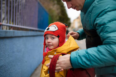 A father taking his little daughter with Down syndrome to school, outdoors in street. - HPIF01080