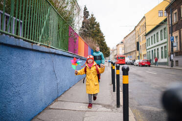 Ein Vater bringt seine kleine Tochter mit Down-Syndrom zur Schule, draußen auf der Straße. - HPIF01081