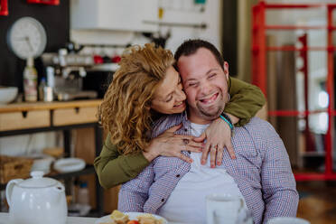 A portrait of mother hugging her grown up son with Down syndrome, motherhood concept. Looking at camera. - HPIF01108