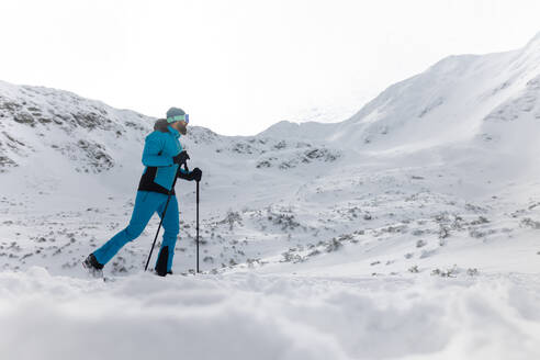 Ein Skitourenpaar beim Wandern in den Bergen aus einem niedrigen Blickwinkel. - HPIF01225