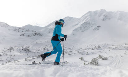 Ein männlicher Skitourengeher auf dem Weg zum Gipfel eines verschneiten Berges in den Schweizer Alpen - HPIF01226