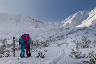 Ein Skitourenpaar macht eine Pause auf dem Gipfel eines Berges in der Niederen Tatra in der Slowakei. - HPIF01227