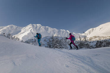 Ein verliebtes Skitourenpaar macht Pause auf dem Gipfel eines Berges in der Niederen Tatra in der Slowakei. - HPIF01228