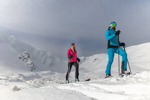 Frontansicht eines Skitourenpaares, das in der Niederen Tatra in der Slowakei einen Berg hinaufwandert. - HPIF01235