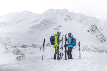A ski touring couple taking break on the top of mountain in the Low Tatras in Slovakia. - HPIF01240