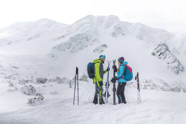 Ein Skitourenpaar macht eine Pause auf dem Gipfel eines Berges in der Niederen Tatra in der Slowakei. - HPIF01240