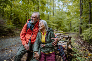 Ein älteres Ehepaar macht eine Pause beim Wandern im Herbstwald. - HPIF01301