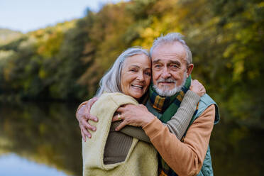 Verliebtes älteres Paar umarmt sich im Herbstwald. - HPIF01340