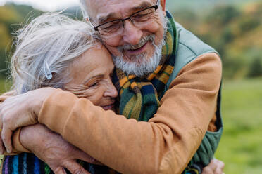 Verliebtes älteres Paar umarmt sich im Herbstwald. - HPIF01345