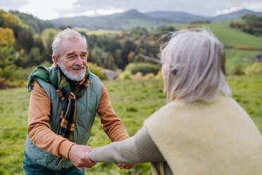Glückliches älteres Paar beim Spaziergang in der herbstlichen Natur. - HPIF01350