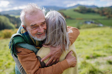 Verliebtes älteres Paar umarmt sich im Herbstwald. - HPIF01351