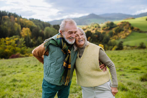 Happy senior couple walking in autumn nature. - HPIF01353