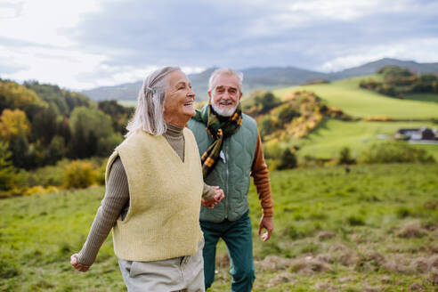 Happy senior couple walking in autumn nature. - HPIF01354