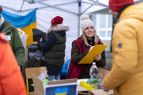 Die Freiwilligen verteilen Lebensmittel und Getränke an Flüchtlinge an der ukrainischen Grenze, Konzept der humanitären Hilfe. - HPIF01371