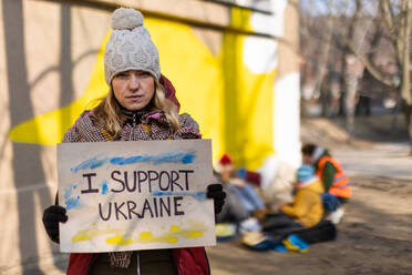Protest gegen die russische Invasion in der Ukraine: Eine Frau hält in der Nähe eines Flüchtlingslagers ein Transparent gegen den Krieg. - HPIF01399
