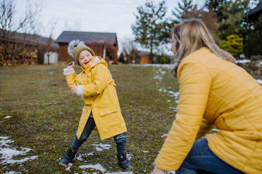 Ein Junge mit Down-Syndrom und seine Mutter spielen mit Schnee im Garten. - HPIF01461