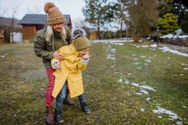 Ein Junge mit Down-Syndrom und seine Mutter spielen im Winter im Garten. - HPIF01462