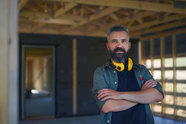 A portrait of construction worker smiling and looking at camera, diy eco-friendly homes concept. - HPIF01540
