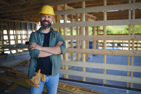 A portrait of construction worker smiling and looking at camera, diy eco-friendly homes concept. - HPIF01560