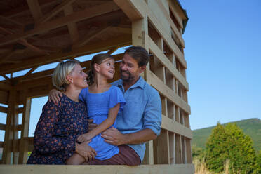 Eine junge Familie auf der Baustelle im Rahmen eines neuen Hauses. - HPIF01577