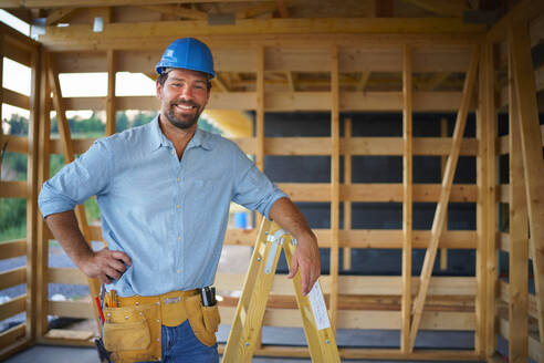 Ein Porträt von Bauarbeiter lächelnd und Blick auf die Kamera, diy umweltfreundliche Häuser Konzept. - HPIF01612