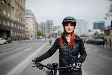 Porträt einer Geschäftsfrau, die mit dem Fahrrad zur Arbeit fährt, Konzept des nachhaltigen Lebensstils. - HPIF01728