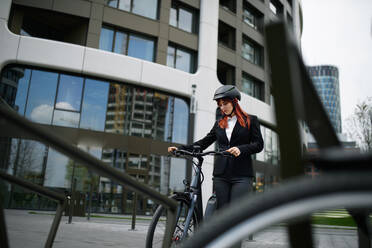 Porträt einer Geschäftsfrau, die mit dem Fahrrad zur Arbeit fährt, Konzept des nachhaltigen Lebensstils. - HPIF01742