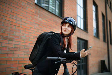 Porträt einer Geschäftsfrau, die mit dem Fahrrad zur Arbeit fährt, Konzept des nachhaltigen Lebensstils. - HPIF01747